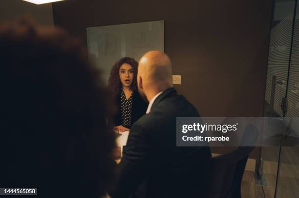 compañeros de trabajo hablando en la mesa - trabalho comercial fotografías e imágenes de stock