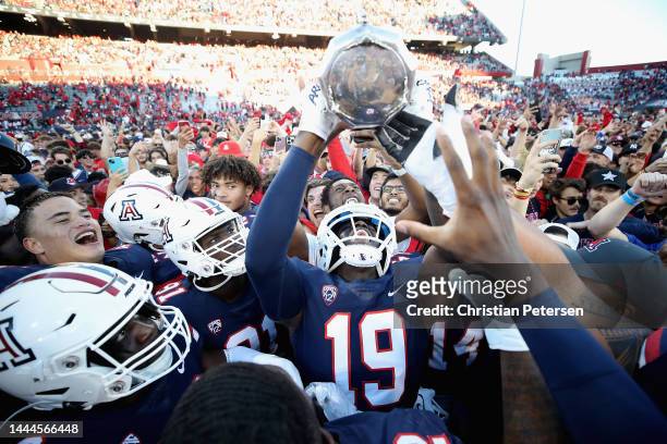 Cornerback Adama Fall of the Arizona Wildcats holds up the Territorial Cup after defeating the Arizona State Sun Devils 38-35 in NCAAF game at...