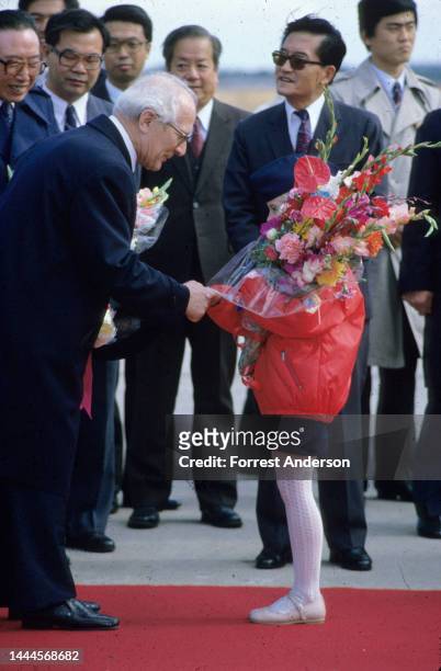 East German leader Erich Honecker greets a young flower bearer at a welcoming ceremony, Beijing, China, 1980s.