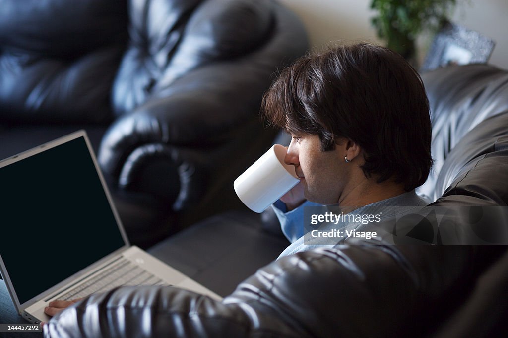 Side view of a man working on a laptop
