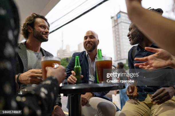 compañeros de trabajo brindando y bebiendo - trabalho comercial fotografías e imágenes de stock