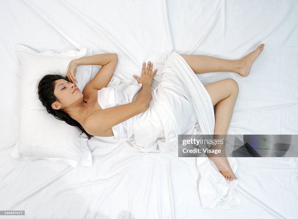 Young woman lying in bed