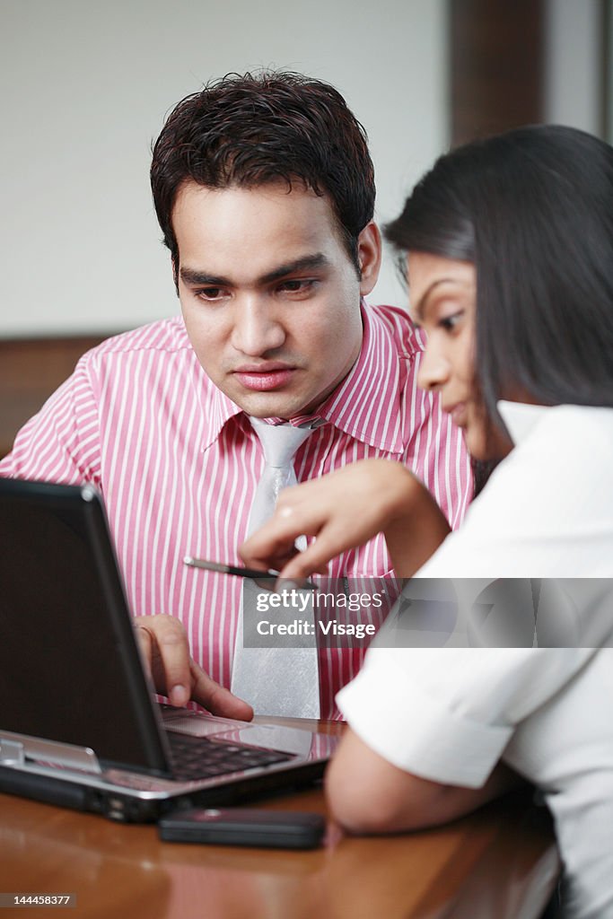 Businessman and businesswoman working on laptop