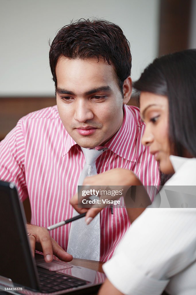 Businessman and businesswoman working on laptop