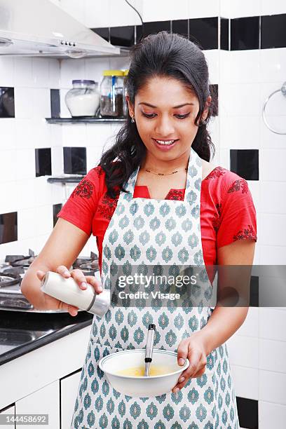 woman adding salt into a mixture - adicionar sal - fotografias e filmes do acervo