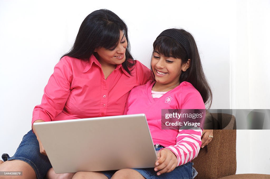Mother and daughter working on laptop