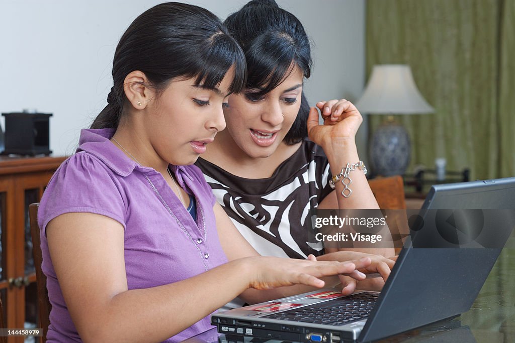 Mother and daughter using laptop