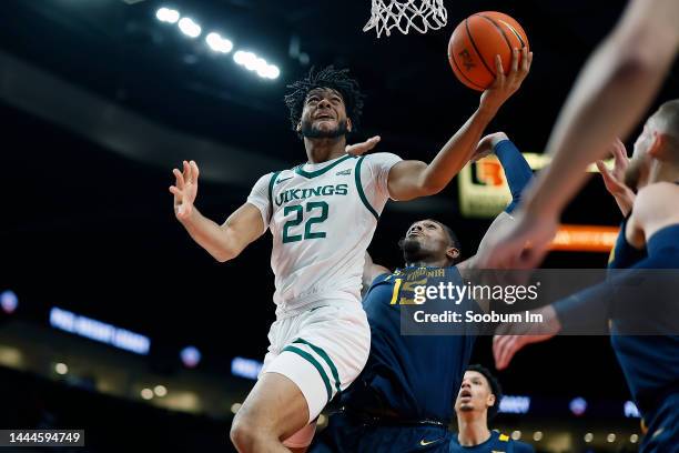 Isaiah Johnson of the Portland State Vikings shoots under pressure from Jimmy Bell Jr. #15 of the West Virginia Mountaineers during the first half at...