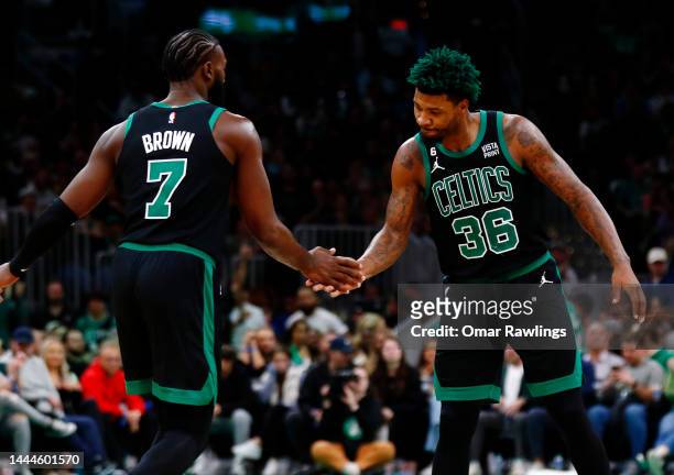 Marcus Smart of the Boston Celtics and Jaylen Brown of the Boston Celtics low-five during the fourth quarter of the game against the Sacramento Kings...