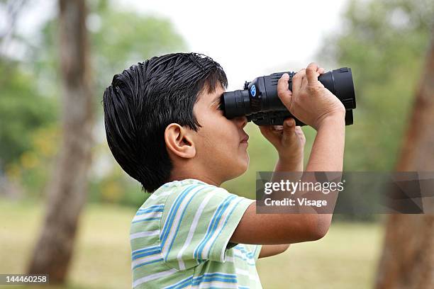 boy looking through binoculars, side view - asian child with binoculars stockfoto's en -beelden
