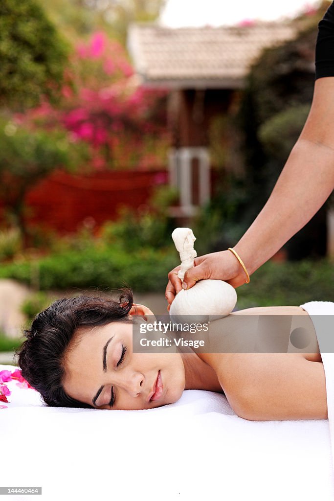 Young woman getting Kizhi treatment