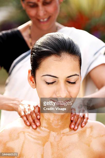 young woman getting pizhichil treatment - pizhichil stockfoto's en -beelden