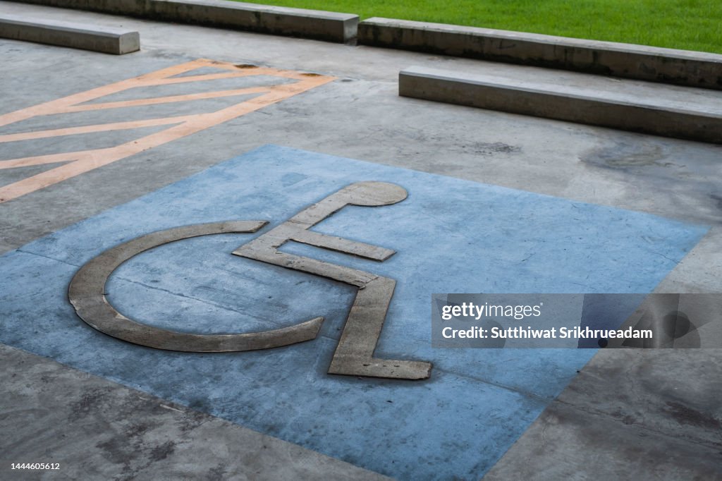Handicapped Parking Sign Painted On The Ground In Public Parking Lot