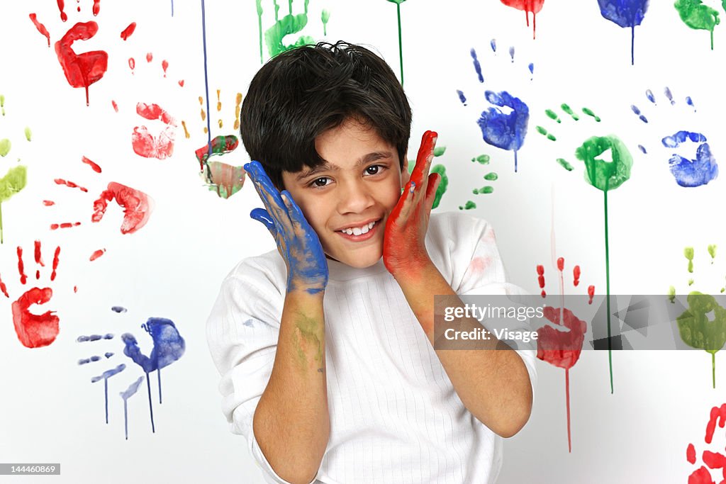 Boy with smeared hands rubbing to his face