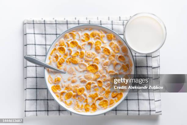 dry honey cornflakes in a ceramic plate on the dining table at home or on a white background. flakes with organic farm vegetable soy, almond or animal milk. top view, copy space. the concept of healthy eating, vegetarian and vegan food for breakfast. - bowl of cereal stock pictures, royalty-free photos & images