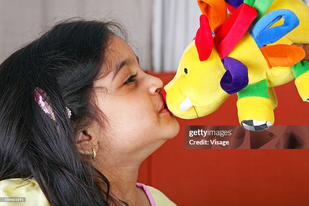 Young girl kissing a soft toy