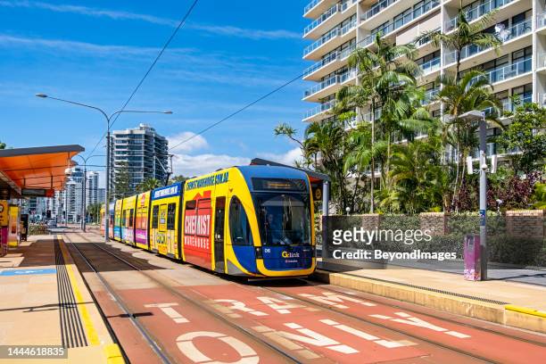 gold coast light rail vehicle with all-over advertising in surfers paradise - gold coast light rail stock pictures, royalty-free photos & images