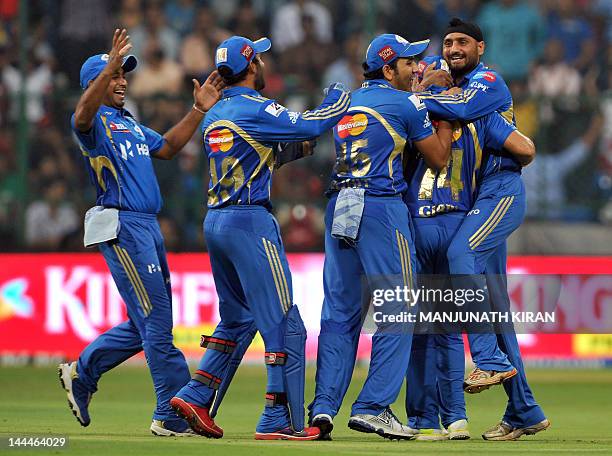 Mumbai Indians captain Harbhajan Singh celebrates with teammates the wicket of Royal Challengers Bangalore batsman Virat Kohli during the IPL...