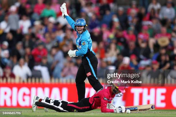 Tegan McPharlin of the Strikers successfully appeals for a stumping for the wicket of Erin Burns of the Sixers during the Women's Big Bash League...