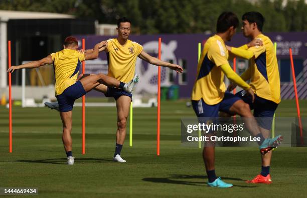 Maya Yoshida and Yuto Nagatomo of Japan stretch during the Japan Training Session at Al Sadd SC New Training Facilities on November 26, 2022 in Doha,...