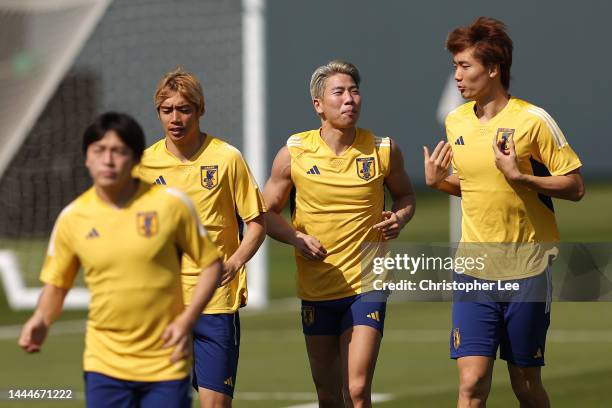 Takuma Asano and Kou Itakura of Japan warm up with teammates during the Japan Training Session at Al Sadd SC New Training Facilities on November 25,...