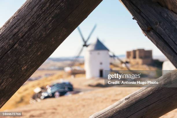 white windmills and medieval castle. consuegra, spain. - don quixote stockfoto's en -beelden