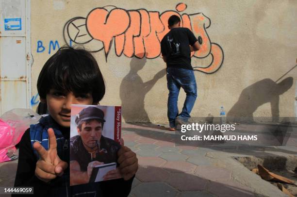 Palestinian boy holds a picture of Italian activist Vittorio Arrigoni in Gaza City on April 14 as Gazans marked the first anniversary of his murder...