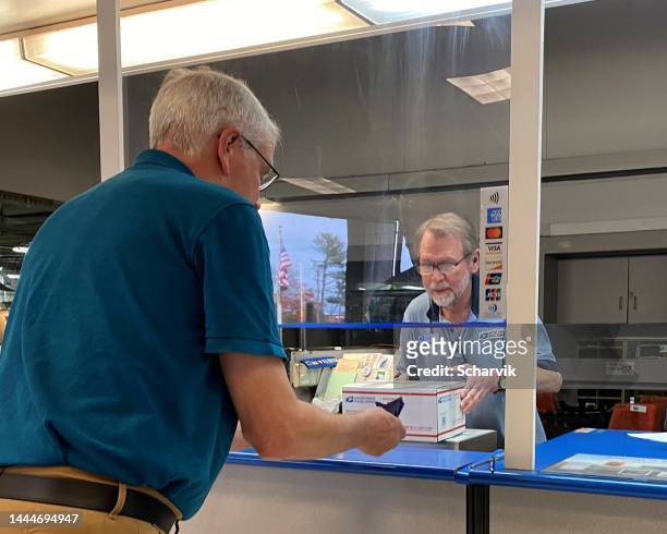 man sending a  cardboard box in postoffice ; charlottesville, virginia - public service stock pictures, royalty-free photos & images