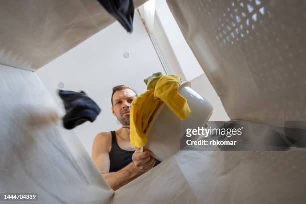 man doing laundry at home - housework - smelly laundry stock pictures, royalty-free photos & images