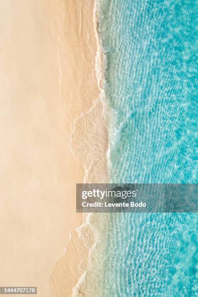 summer seascape beautiful waves, blue sea water in sunny day. top view from drone. sea aerial view, amazing tropical nature background. beautiful bright sea waves splashing and beach sand sunset light - ozeanien stock-fotos und bilder