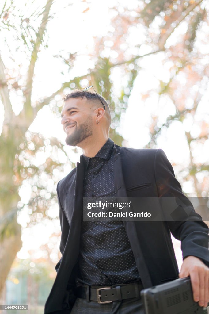 Businessman smiling, business in the city, man in black suit, laptop, have a good day