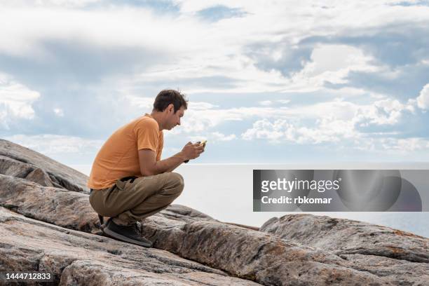 man using smartphone for work while traveling in wilderness - coping stock pictures, royalty-free photos & images
