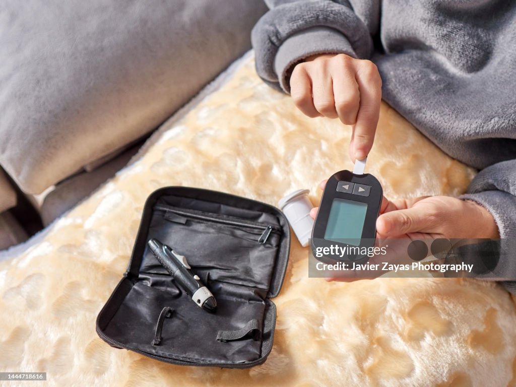 Diabetic Woman Measuring Her Blood Sugar Levels Using A Glucometer