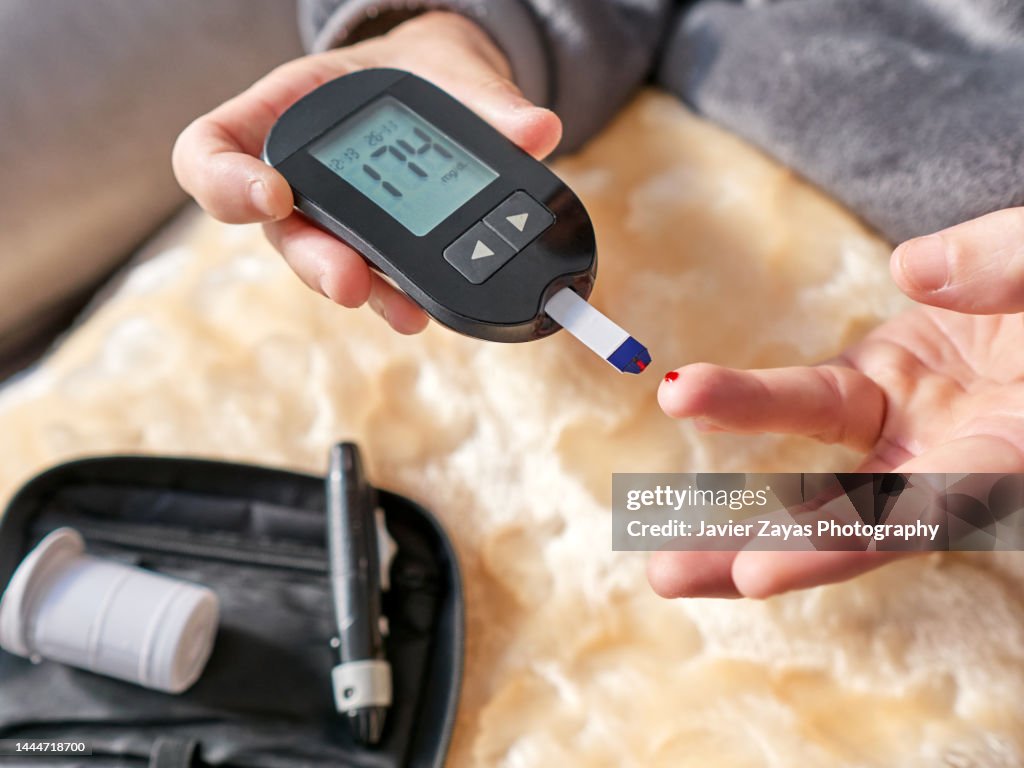 Diabetic Woman Measuring Her Blood Sugar Levels Using A Glucometer