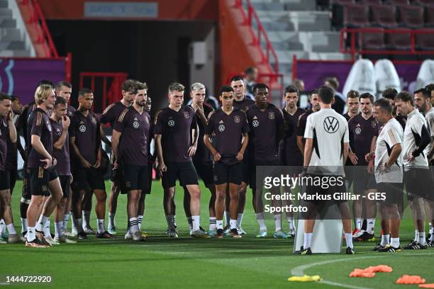 The team watches Assistant coach Danny Roehl and Head Coach Hansi Flick give instructions on a tactic board during the Germany training session at Al...