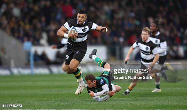 Luther Burrell of the Barbarians runs past Callum Braley of Northampton Saints during the friendly match between Northampton Saints and Barbarians at...