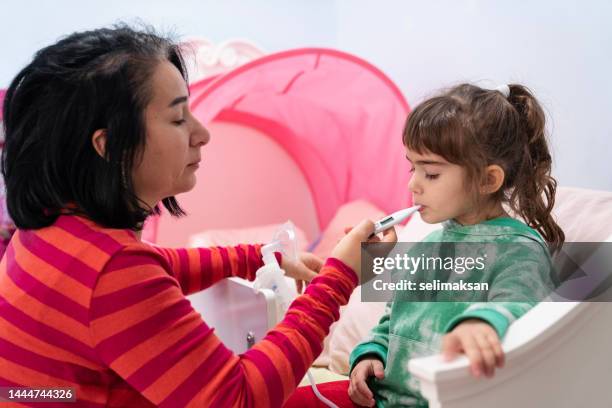 photo of mother taking care of sick daughter - thermometer turkey stock pictures, royalty-free photos & images