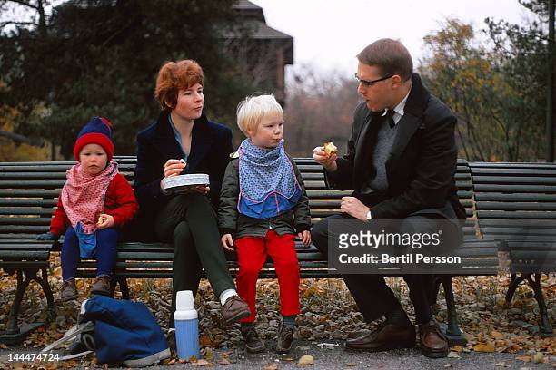 family autumn picnic on park bench - 1967 stockfoto's en -beelden