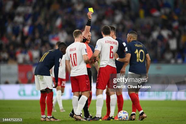 Andreas Christensen of Denmark is shown a yellow card by referee Szymon Marciniak after his challenged on Kylian Mbappe of France during the FIFA...