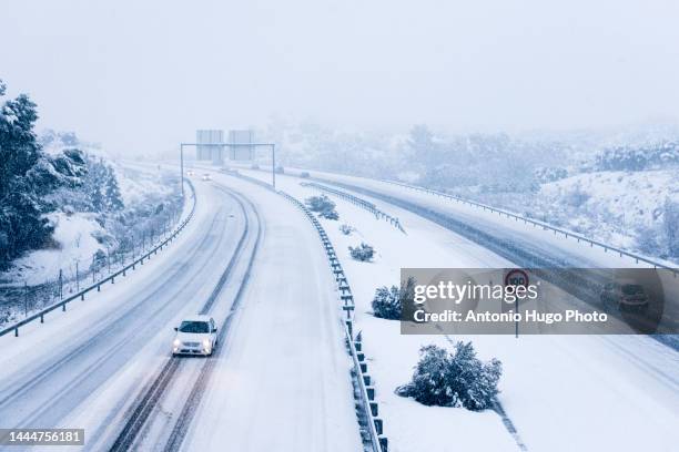 cars driving on a snowy road. - extreme weather events stock pictures, royalty-free photos & images