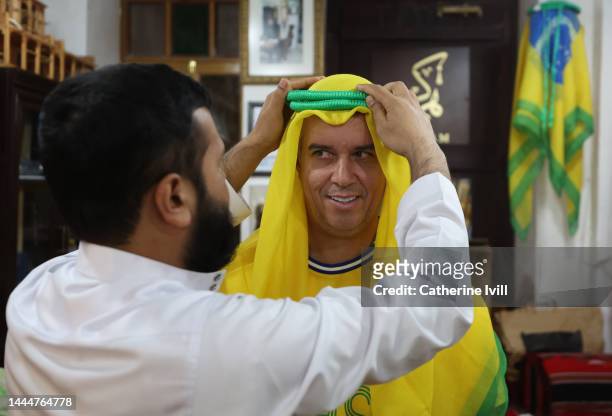 Fan of Brazil has a Ghutra headscarf placed on his head during the FIFA World Cup Qatar 2022 at the Souq Waqif on November 26, 2022 in Doha, Qatar.