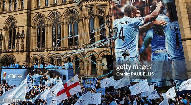 Manchester City players stand with their manager Roberto Mancini as they celebrate becoming English Premier League champions in a parade leaving from...