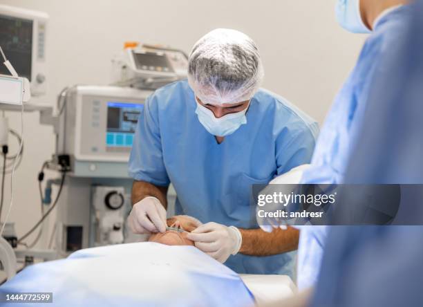 anestesista che prepara un paziente per un intervento chirurgico e mette una cannula nasale - nasal cannula foto e immagini stock