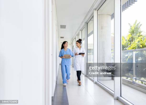arzt und krankenschwester unterhalten sich auf dem flur eines krankenhauses - the resident screening stock-fotos und bilder
