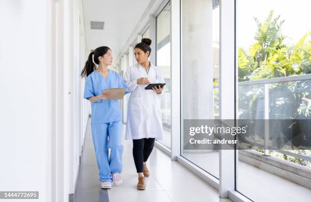 arzt spricht mit einer krankenschwester auf dem flur des krankenhauses - zivilist stock-fotos und bilder