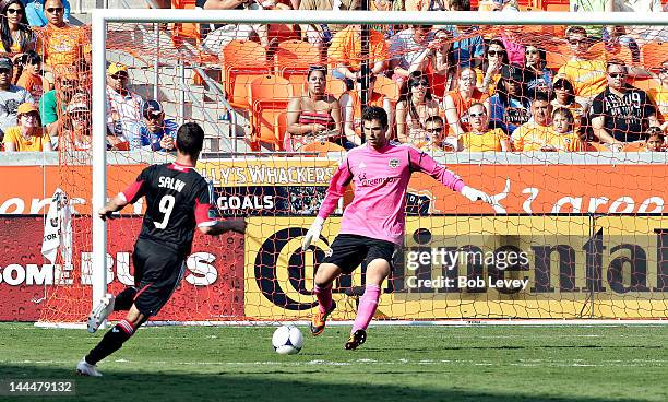 Goalkeeper Tally Hall of the Houston Dynamo clears the ball as Hamdi Salihi of the D.C. United pressures him at BBVA Compass Stadium on May 12, 2012...