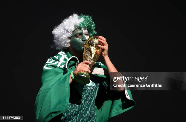 Saudi Arabia fan kisses a replica World Cup Trophy ahead of the FIFA World Cup Qatar 2022 Group C match between Poland and Saudi Arabia at Education...