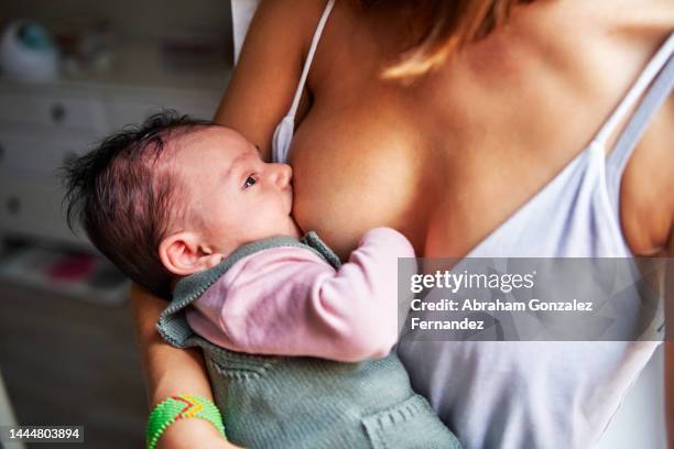 baby sucking the breast of his mother to eat - compassionate eye stock pictures, royalty-free photos & images