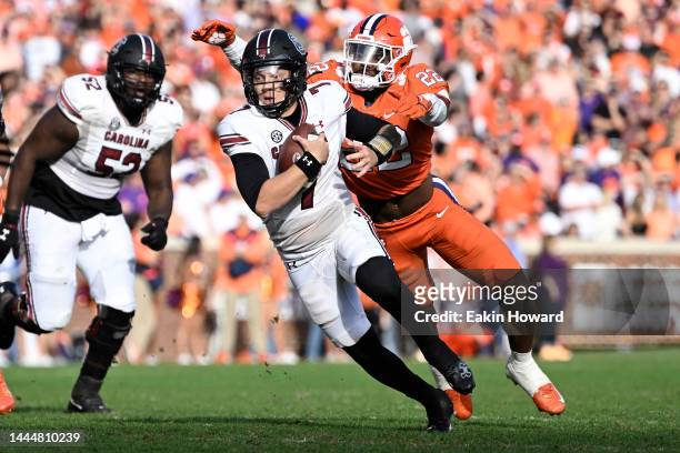 Spencer Rattler of the South Carolina Gamecocks gets tackled by Trenton Simpson of the Clemson Tigers in the fourth quarter at Memorial Stadium on...