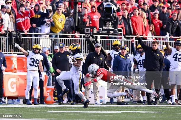Donovan Edwards of the Michigan Wolverines evades a tackle by Lathan Ransom of the Ohio State Buckeyes during the fourth quarter of a game at Ohio...